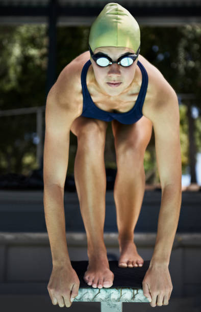 Ready...set... A swimmer on a diving board ready to dive in starting block stock pictures, royalty-free photos & images