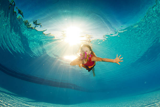 small girl swimming underwater stock photo