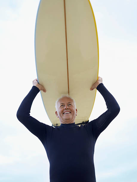 istock Senior Man Carrying Surfboard Over Head 456095467