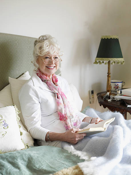 istock Senior Woman Reading Book On Bed 456095957