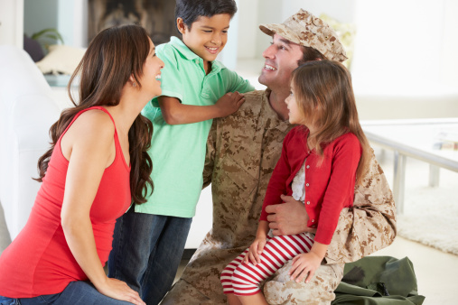 Family Greeting Military Father Home On Leave And Smiling To Each Other