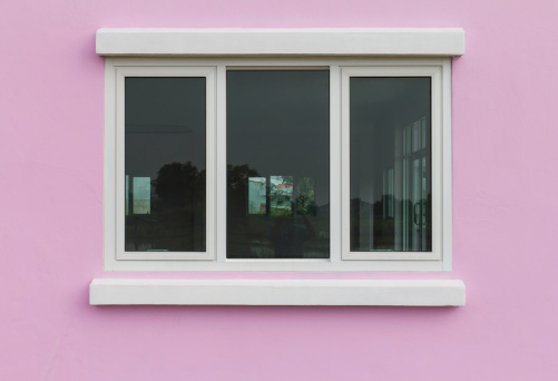 Pink walls and white opaque glass windows reflected trees in the scenic countryside