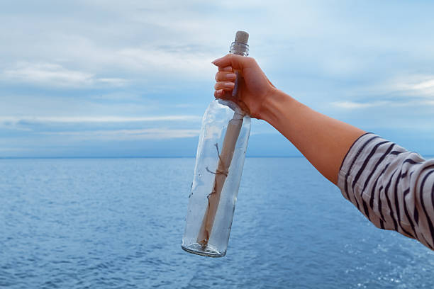istock Woman pulled out bottle with a letter from water 456100067