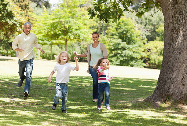 istock Two parents running after their children 456102739