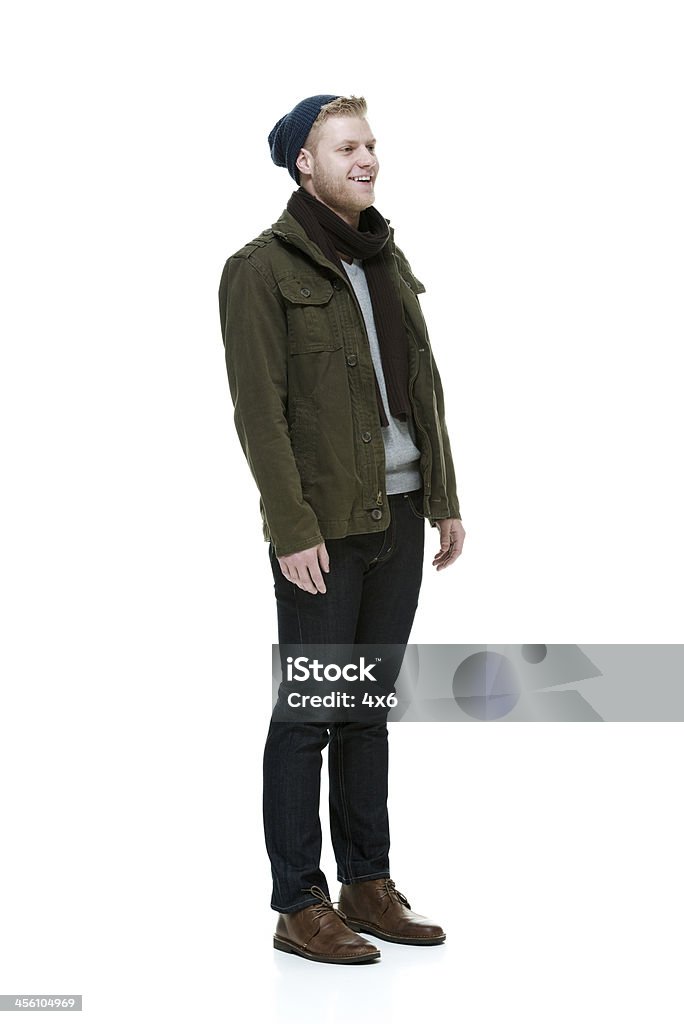 Uomo sorridente in piedi che indossa vestiti invernali - Foto stock royalty-free di Abbigliamento casual