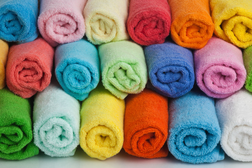 Set of colored towels on white background.
