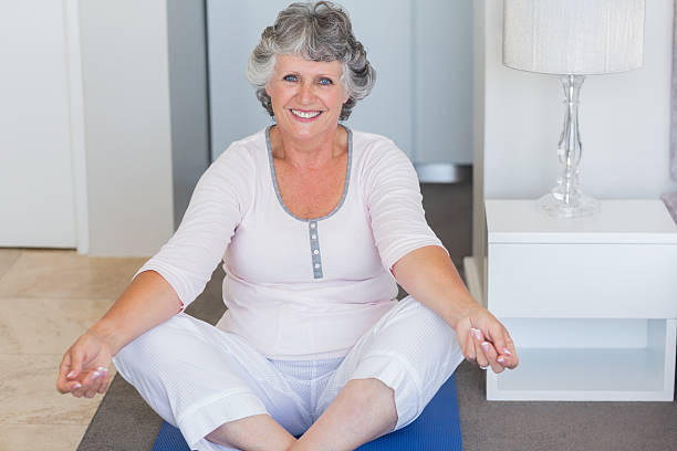 istock Mature woman doing yoga on blue mat 456106197