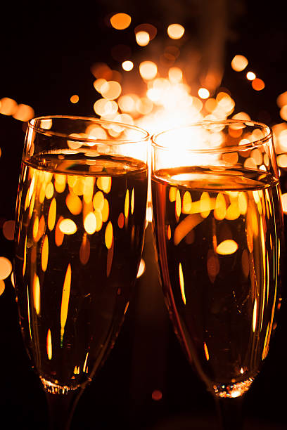 istock champagne glasses against christmas sparkler background 456106377