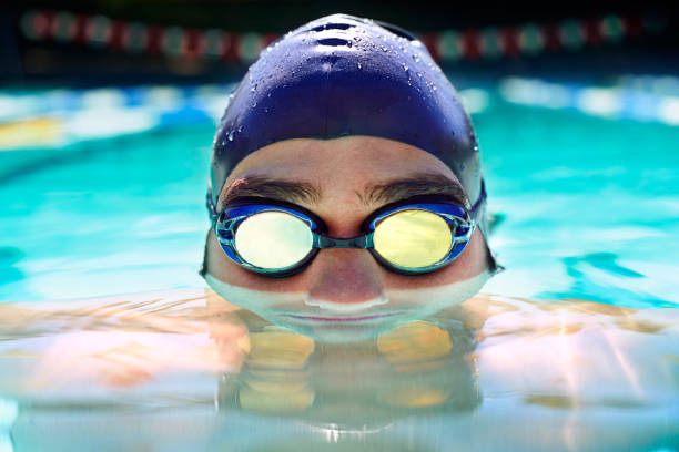 At one with the water Cropped view of a determined male swimmer swimming laps swimming cap stock pictures, royalty-free photos & images