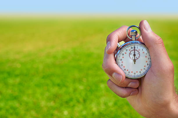 Ready for the time trials Cropped shot of a hand holding a stopwatch against a field stopwatch photos stock pictures, royalty-free photos & images