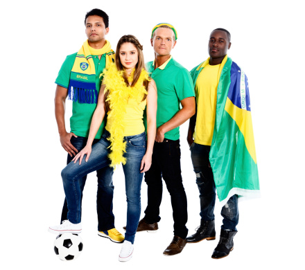 Four serious soccer fans in Brazilian colors look at the camera challengingly, in support of their team.