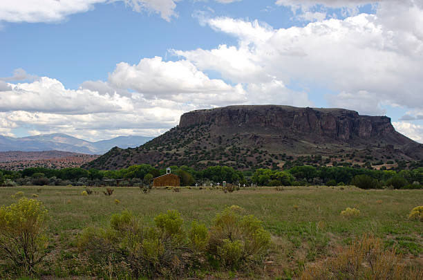 An old cemetery marked with large white crosses, sits next to La Capilla de Sagrada Familia, the Chapel of the Holy Family, at the base of Black Mesa in the San Ildefonso Pueblo in northern New Mexico.