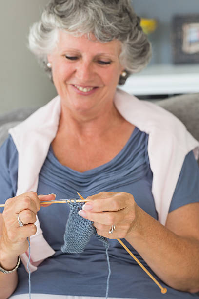 istock Smiling mature woman knitting 456110019