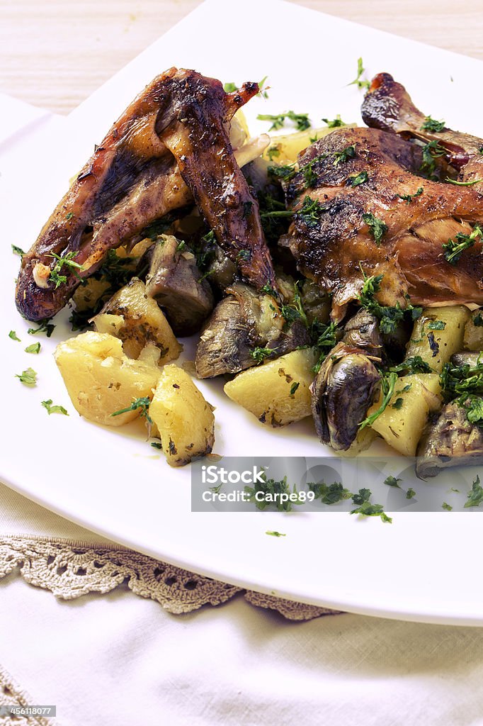 Roast chicken with potatoes and artichokes Animal Body Part Stock Photo