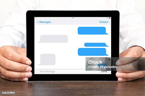 Uomo Daffari Tenendo Un Computer Tablet Con La Chat Con Sms Su Schermo - Fotografie stock e altre immagini di Adulto