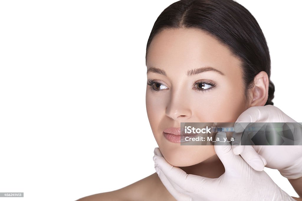 Female model with surgeon hands injecting Botox Close-up of cosmetic injection of botox in women lips Adult Stock Photo