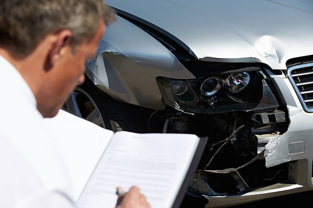 istock Man inspecting a car involved in a accident 456244299