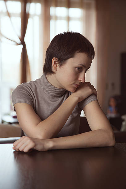 istock Sad woman sitting with hands clasped 456246723