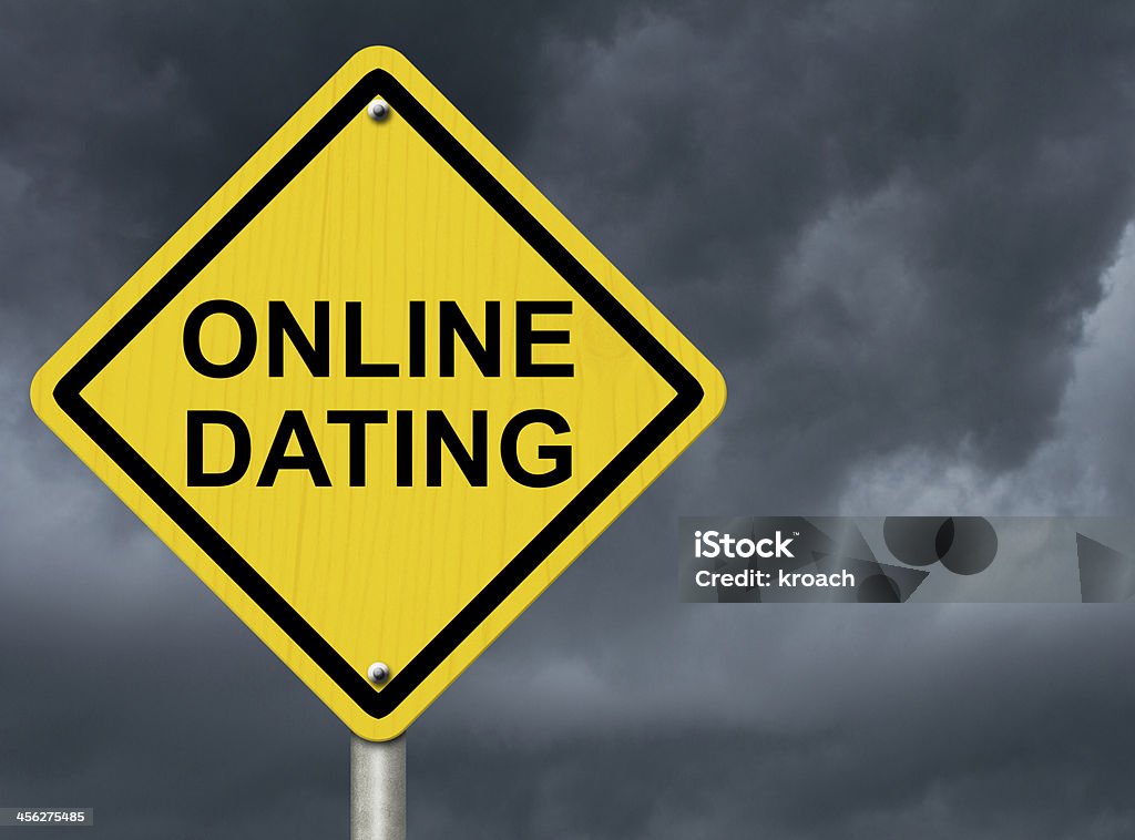 Warning of OnLine Dating A road warning sign against a stormy sky with words Online Dating, Warning about Online Dating Black Color Stock Photo
