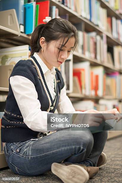 Mujer Leyendo Un Libro Cerca De Estantería De Libros Foto de stock y más banco de imágenes de Adulto