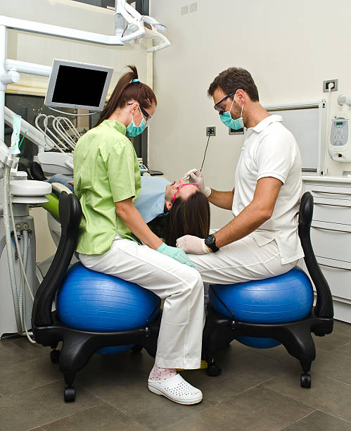 Dentista, asistente y paciente en clínica dental - foto de stock