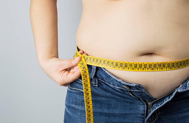 obese woman measuring her waist