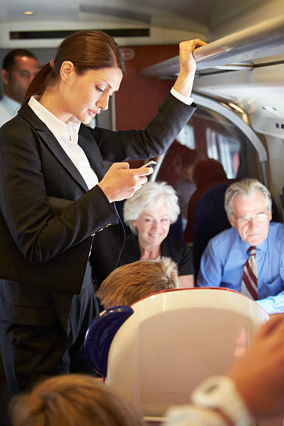 istock Businesswoman Using Mobile Phone On Busy Commuter Train 456509993