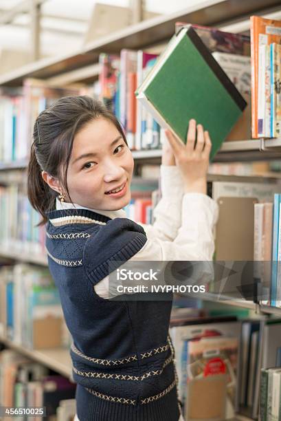 Donna Prendendo Un Libro Dalla Libreria - Fotografie stock e altre immagini di Adulto - Adulto, Ambientazione interna, Arrivo