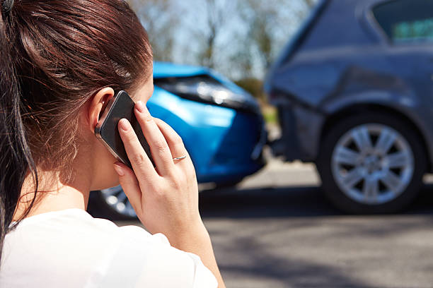 destornillador mujer haciendo una llamada telefónica después del accidente de tráfico - accidente de automóvil fotos fotografías e imágenes de stock