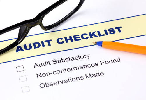 Audit checklist with ballpoint pen and glasses