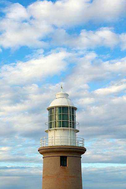 Lighthouse with blue sky and white cloud background stock photo