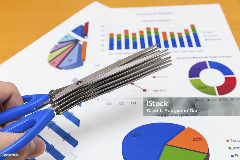 Financial Report and Scissors A financial report with graphs and charts and a pair of scissors. Analyzing Stock Photo