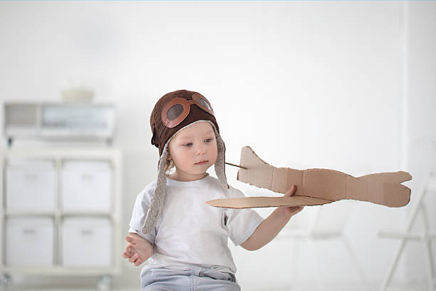 istock Happy pilot boy playing with cardboard airplane in room 456533689