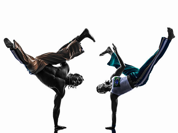 istock Silhouette of two capoiera dancers against white background 456533749