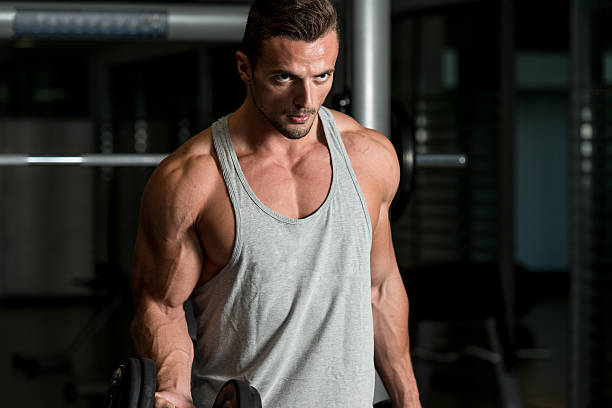 istock Man In The Gym Exercising Biceps With Dumbbells 456533755