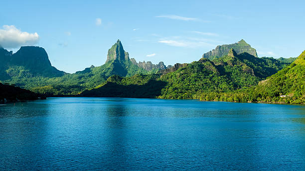 Mountainous coast of Moorea in Tahiti from ocean View of a mountain range from an inlet off the coast of Moorea, an island belonging to Tahiti in the South Pacific Ocean. french polynesia stock pictures, royalty-free photos & images