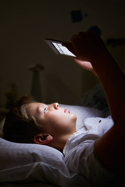 istock Boy Looking On Digital Tablet In Bed At Night 456582557