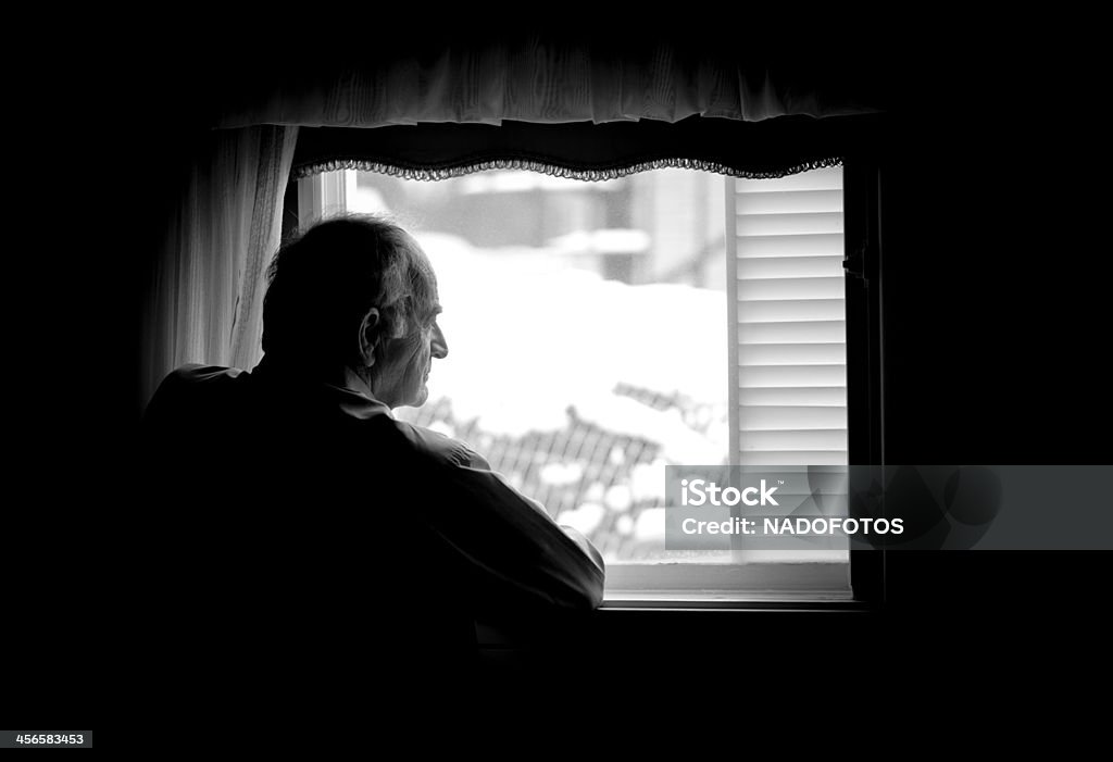 Lonely senior man looking at the window Senior Adult Stock Photo