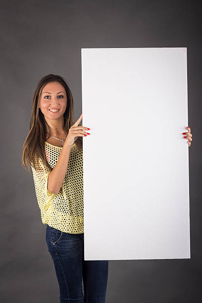 istock Young woman with blank board banner 456607269