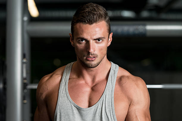 istock Man Lifting Dumbbell In Gym 456607427