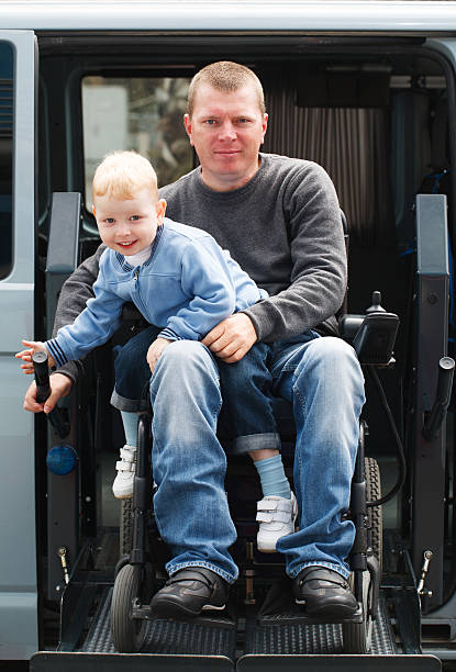 Disabled Men with son on Wheelchair Lift 4 year old boy and 35 year old Disabled Men on Wheelchair  wheelchair lift stock pictures, royalty-free photos & images