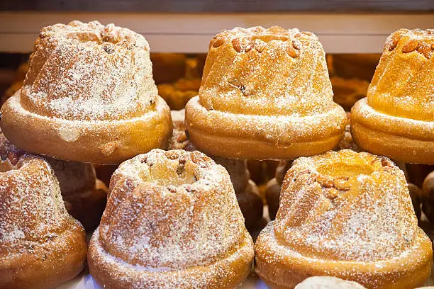 The cake of the Advent season known as Kugelhopf, Kougelhof, Kouglof, Gugelhupf and many other variations. With various recipes that have been adapted in France, in the Alsace region, in Germany, in Switzerland and in Austria it is particular popular during the December festive season. The brioche style cake is traditionally made in the raised ring shape as seen here, with an almond topping and sprinkled with icing sugar. These are for sale at an Advent Christmas Market in France.