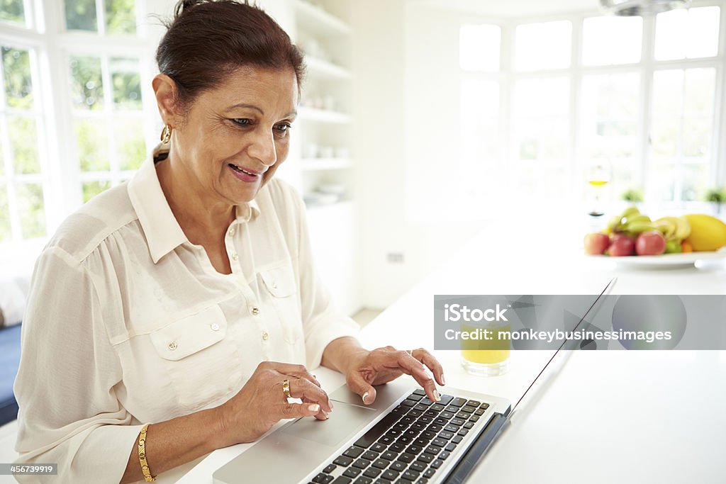 Senior Indian Woman Using Laptop At Home Senior Indian Woman Typing On Laptop At Home Senior Adult Stock Photo