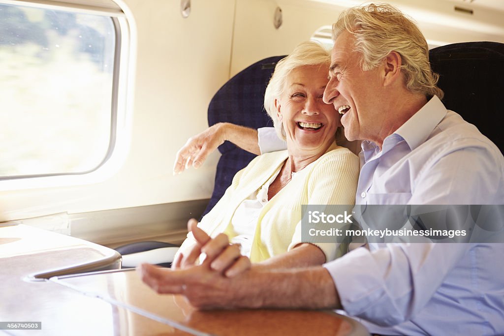 Senior Couple Relaxing On Train Journey Senior Couple Relaxing & cuddling On Train Journey Train - Vehicle Stock Photo