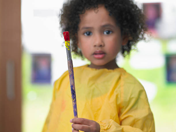 istock Girl Holding Paintbrush In Art Class 456746005