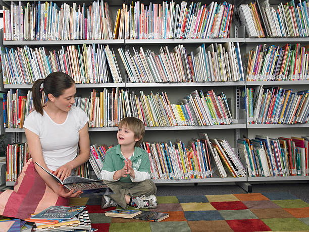 istock Woman Reading Book To Boy In Library 456748799