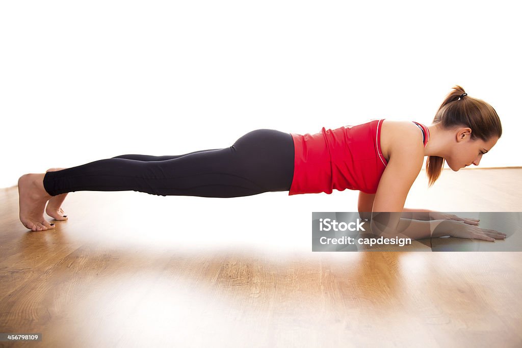 Studio shot of young woman doing plank exercise Young woman exercising - doing a plank in a studio Exercising Stock Photo