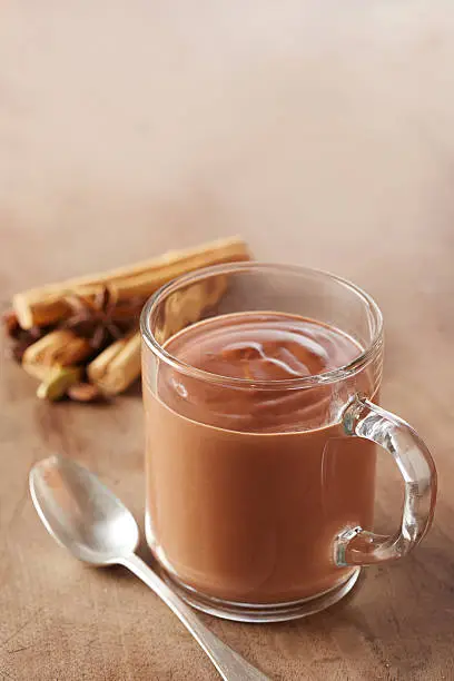 Hot chocolate in a glass cup with cinnamon and aniseed