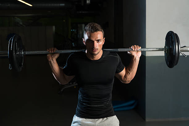 istock Young Man In Black T-Shirt Doing Barbell Squat 456800385