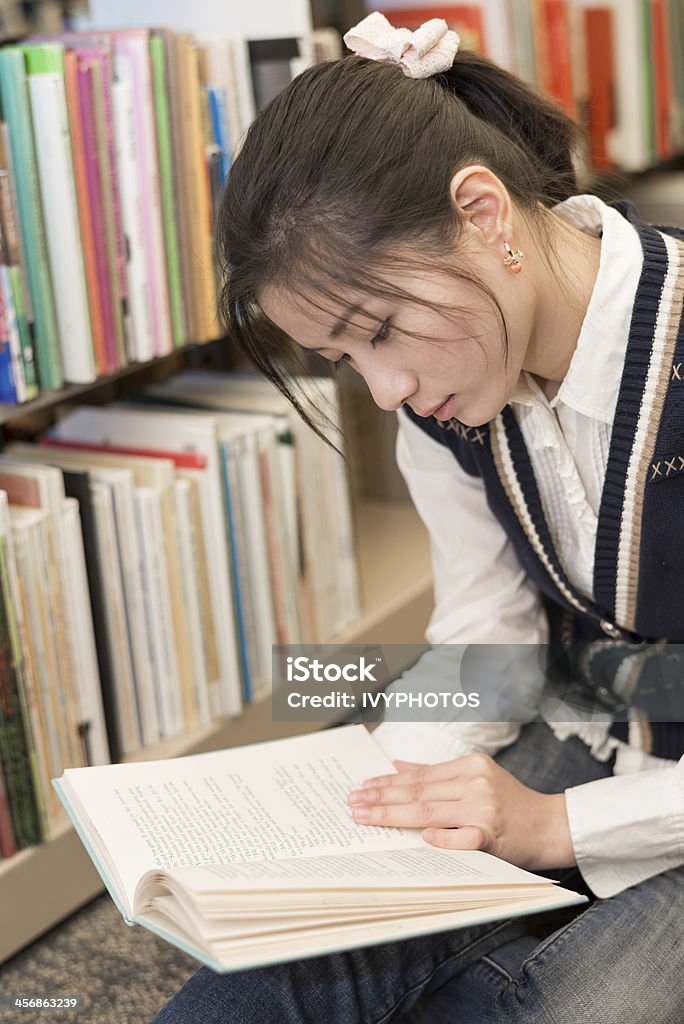 Mulher lendo um livro, perto estante - Foto de stock de Adulto royalty-free